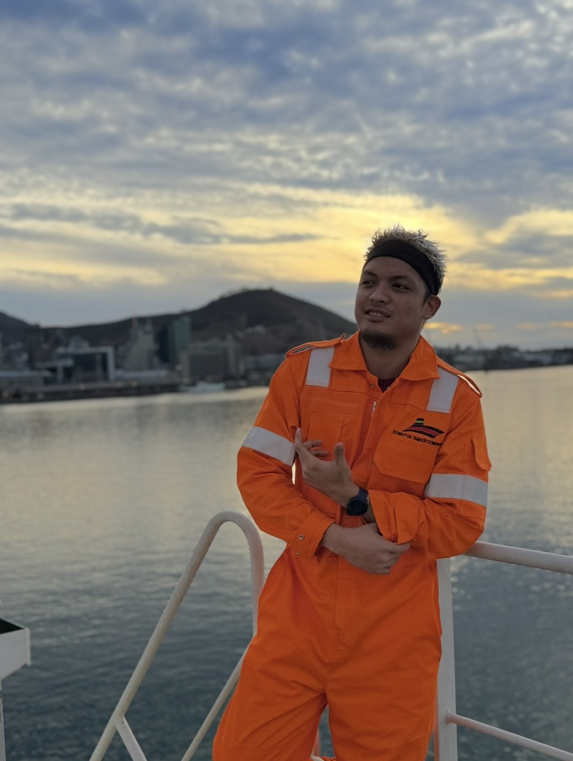 John Vincent Ursal onboard at sunset in orange coveralls